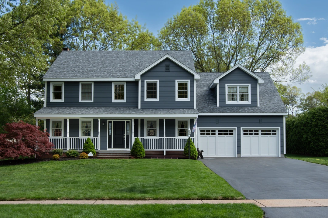 Spring renovation project featuring new windows, doors and blue vinyl siding.